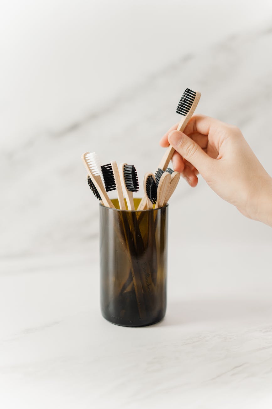 person holding wooden toothbrush